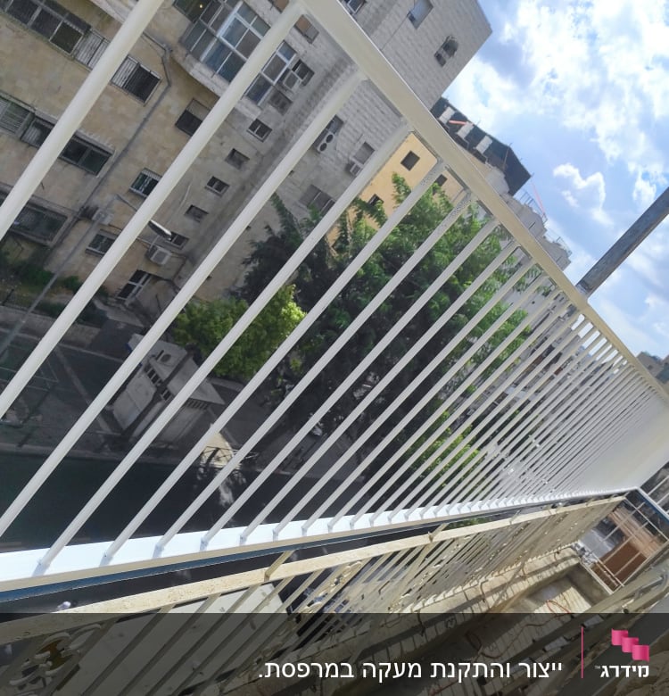 מעקה מתכת לבן עם סורגים אנכיים